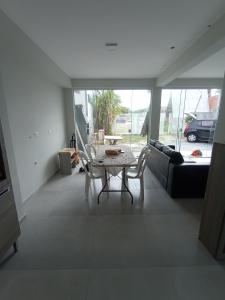 a living room with a table and a couch at Casa 2 quartos a 2 quadras do mar nova in Matinhos