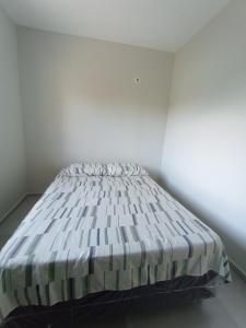 a bed in a white room with a mattress at Casa 2 quartos a 2 quadras do mar nova in Matinhos