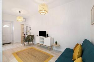 a living room with a blue couch and a tv at Casa Belice in Vila Real de Santo António