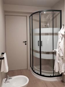 a bathroom with a glass shower and a sink at VHĀUS Apartment and Spa in Predazzo +35 photos