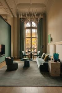 a living room with a couch and a chandelier at Rosewood Amsterdam in Amsterdam