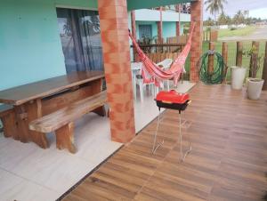 a porch with a hammock and a bench and a table at Paradise in Estância