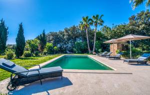 a swimming pool with two chairs and an umbrella at Esteva in Sant Llorenç des Cardassar