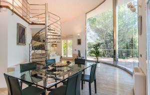 a dining room with a glass table and chairs and a spiral staircase at Cocodrilo in Alcudia