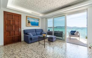 a living room with a blue couch and a glass door at Voramar On Pinewalk in Pollença