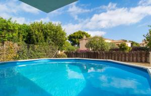 a large blue swimming pool in a yard at Es Ganxo House in Porto Cristo
