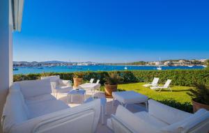 a patio with white furniture and a view of the water at Esperanza in Portocolom