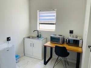 a kitchen with a wooden table with a microwave and a counter at Maita Corner in Monte Vista