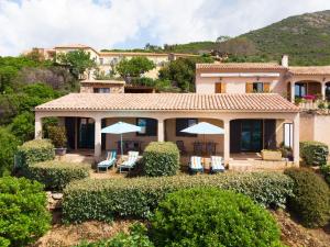 a house with chairs and umbrellas in front of it at Roc A Mare in Galeria
