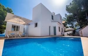 a villa with a swimming pool in front of a house at Mar Bella Nou in Font de Sa Cala
