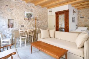 a living room with a couch and a table at Rastoni 1928 Heritage Residence in Egina