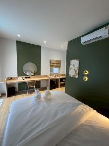 a bedroom with a white bed with a green wall at The Pool House Koh Lanta in Ko Lanta +36 photos