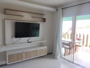 a living room with a flat screen tv on a wall at Paradise in Estância