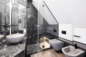 a bathroom with two sinks and a toilet and a shower at Hotel Michelangelo in Riccione