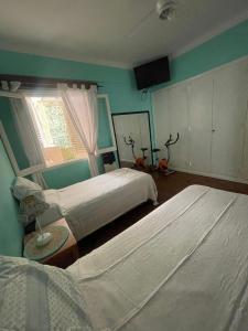 a bedroom with two beds and a television in it at Miramar2026 in Miramar