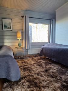 a bedroom with two beds and a window at Villa Irjala in Oulu