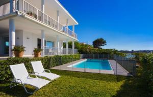 a house with a swimming pool and two chairs at Esperanza in Portocolom +51 photos