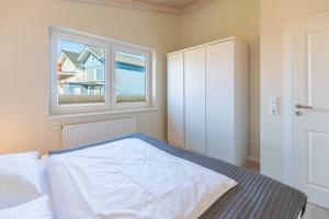 a bedroom with a bed and a window at Ferienhaus Strandflieder in Dagebüll