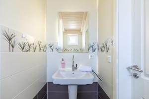 a bathroom with a sink and a mirror at Ferienhaus Strandflieder in Dagebüll +19 photos