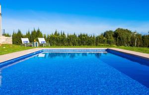 a blue swimming pool with two chairs in a yard at Finca Llum in Manacor