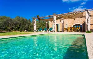 a pool in front of a house with chairs and a patio at Ses Fonolleres in Son Servera