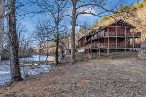 a large wooden house on the side of a river at Riverfront Lodge in Tellico Plains