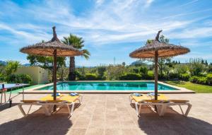 two chairs and umbrellas next to a swimming pool at Ca Na Neus Pollenca in Pollença +34 photos