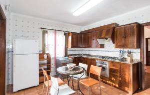 a kitchen with wooden cabinets and a table with chairs at Ca Na Siona in Alcudia