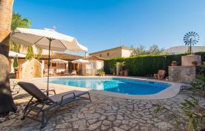 a swimming pool with a chair and an umbrella at Casa Romantica De Sa Coma in Sa Coma