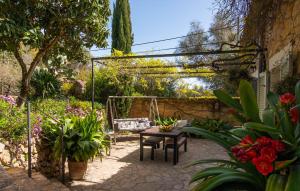 a garden with a table and chairs and flowers at Can Pintad in Ruberts