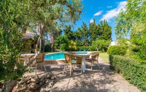a patio with a table and chairs next to a swimming pool at Can Bleio in Pollença