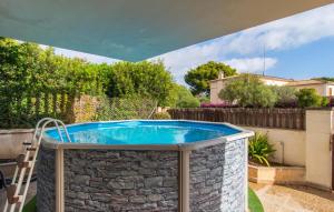 a swimming pool in a yard with a stone wall at Es Ganxo House in Porto Cristo