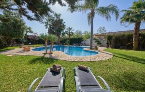 a pool with two lounge chairs in a yard at Can Gual in Inca