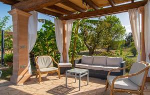 a patio with a couch and two chairs and a table at Sa Plana Port Nou in Cala Millor