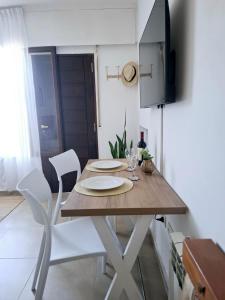 a dining room table with two chairs and a television at Monoambiente luminoso con Jacuzzi Relax y estilo in Córdoba