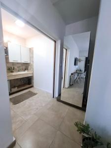 a kitchen with white cabinets and a large mirror at Monoambiente luminoso con Jacuzzi Relax y estilo in Córdoba