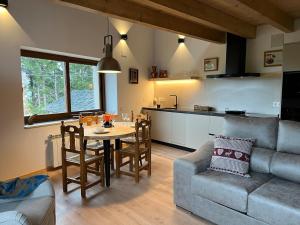 a kitchen and living room with a table and a couch at Cal Not Celler, Cerdanya in Escardacs
