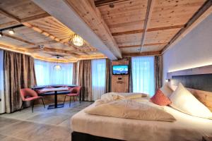 a bedroom with a bed and a table with chairs at Appartement Chesa Monte in Ischgl