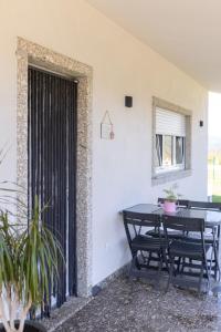a patio with a table and chairs and a window at Encosta da Cabreira in Vieira do Minho