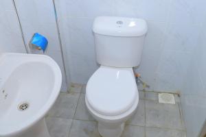 a bathroom with a white toilet and a sink at Naivera Membly Star Heights in Ruiru +24 photos