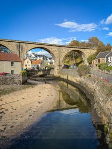 a bridge over a river in a town at Creel Cottage, Lower Largo in Lower Largo