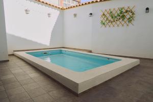 a large swimming pool in a room with a tile floor at Casilla Soleá Rural in Carcabuey