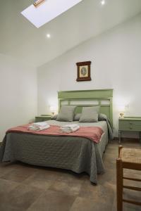 a bedroom with a bed and a clock on the wall at Casilla Soleá Rural in Carcabuey