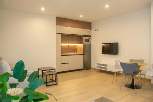 a living room with a kitchen and a table and chairs at Apartamentos ÍCARO in Plasencia
