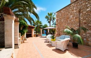 a patio with wicker chairs and palm trees and a building at Can Lopez Vara in Campos +43 photos