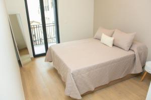a bedroom with a bed with two pillows on it at Apartamentos ÍCARO in Plasencia