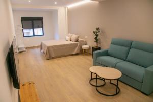 a living room with a couch and a bed at Apartamentos ÍCARO in Plasencia