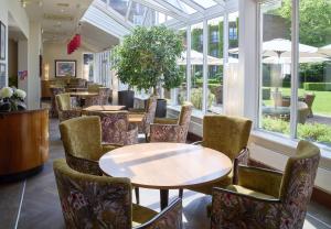 a restaurant with tables and chairs and windows at The Bull in Gerrards Cross