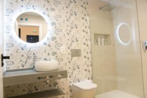 a bathroom with a sink and a toilet and a mirror at Apartamentos ÍCARO in Plasencia +28 photos