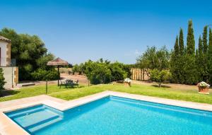 a swimming pool in front of a yard with trees at Can Polito in Can Picafort